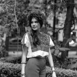 Woman in Mexican folk attire posing outdoors, embodying cultural heritage.